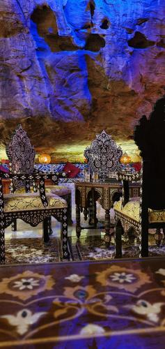 a room with two benches in a cave at Memories Aicha Luxury Camp in Wadi Rum