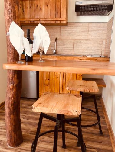 a kitchen with a wooden counter with a sink and stool at Refugio del Maipo Lodge in San José de Maipo