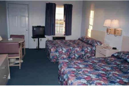 a hotel room with two beds and a television at Talbot Inn in Ocean City