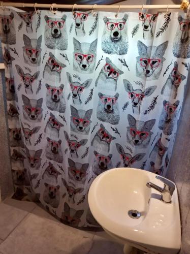a bathroom with a shower curtain with cats and a sink at Lagomar Casa tipo loft in Ciudad de la Costa
