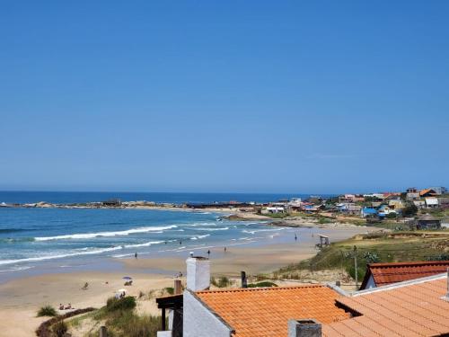 a view of a beach with people in the water at Lobos de Mar in Punta Del Diablo