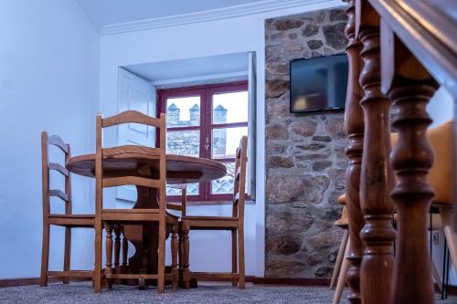 een kamer met 2 stoelen, een tafel en een tv bij Portas da Villa in Miranda do Douro
