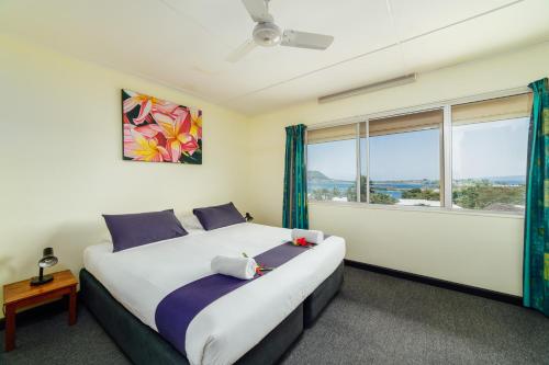 um quarto com uma cama grande e uma janela em Kaiviti Motel em Port Vila