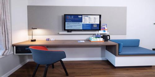 a desk with a computer monitor and a chair at Holiday Inn Express Zhoushan Dinghai by IHG in Zhoushan
