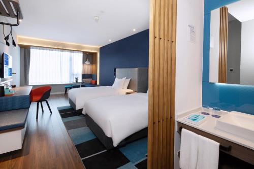 a hotel room with two beds and a bathroom at Holiday Inn Express Zhoushan Dinghai by IHG in Zhoushan