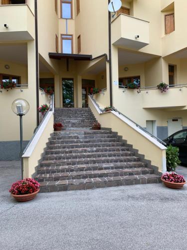 a set of stairs leading to a building with flowers at Appartamento sirente in Rovere