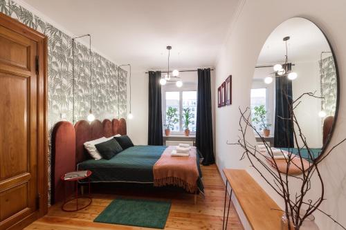 a bedroom with a bed and a mirror at House Apartments Centrum Poznań in Poznań