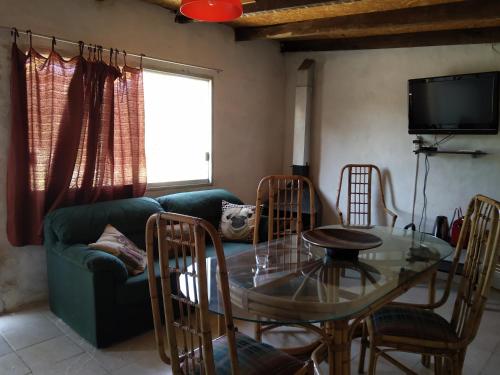 un soggiorno con un tavolo di vetro e un divano di Los Caranchos I a Cuchilla Alta