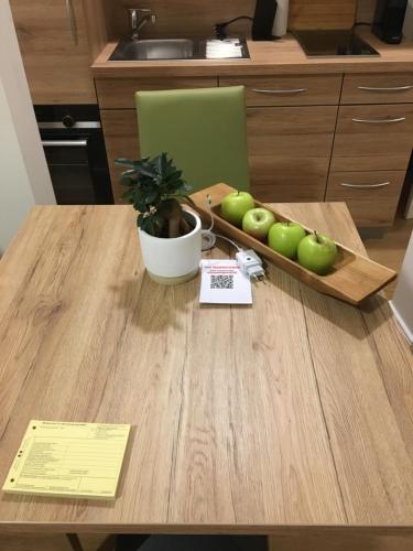 a table with a tray of green apples on it at Perkeo Apartments in Heidelberg