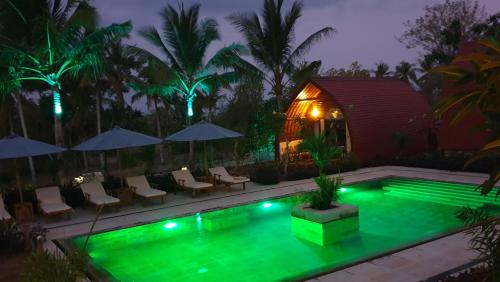 a swimming pool at night with a gazebo at Jungle Paradise in Nusa Penida