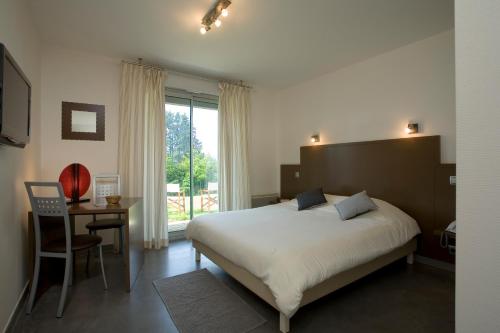 een slaapkamer met een bed, een tafel en een raam bij Bel Horizon in Le Chambon-sur-Lignon