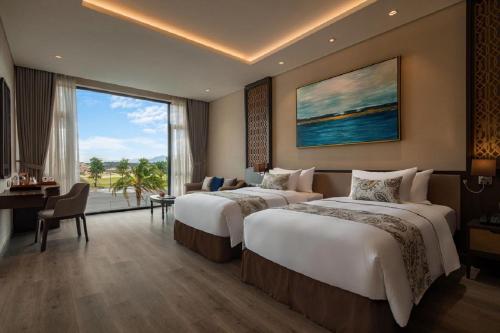 a hotel room with two beds and a large window at Wyndham Grand KN Paradise Cam Ranh in Cam Ranh