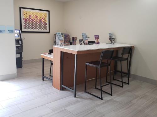 a counter with two stools in a room at Holiday Inn Express Tampa North Telecom Park by IHG in Tampa