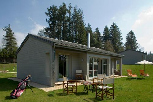 a small shed with a table and chairs in a yard at Bel Horizon in Le Chambon-sur-Lignon