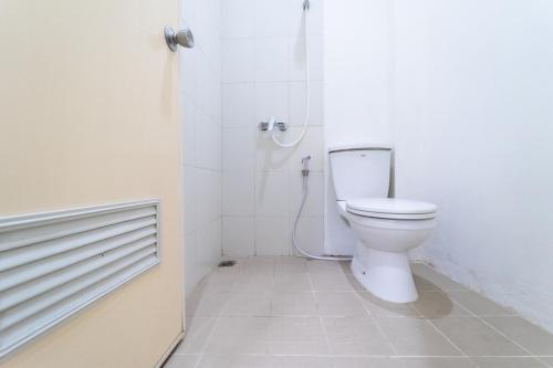een witte badkamer met een toilet en een douche bij KoolKost near Ragunan Zoo - Minimum Stay 6 Days in Jakarta