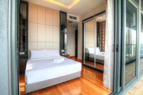 a bedroom with a white bed and a balcony at Vale Pine Dorsett Residences Bukit Bintang in Kuala Lumpur