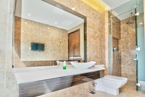 a bathroom with a sink and a toilet and a mirror at Vale Pine Dorsett Residences Bukit Bintang in Kuala Lumpur