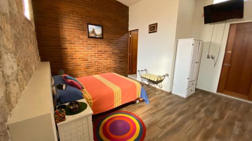 a bedroom with a bed and a brick wall at Casa Ana Celia in Morelia