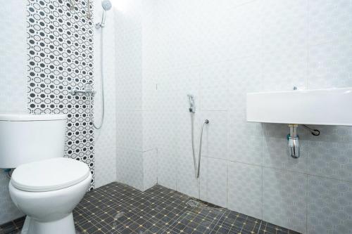 La salle de bains est pourvue de toilettes, d'un lavabo et d'une douche. dans l'établissement RedDoorz Syariah near Exit Toll Ciawi, à Bogor