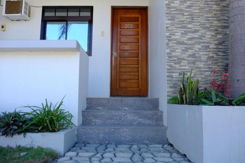 a house with a wooden door and some plants at Pacific Waves Inn (Annex) in Baler