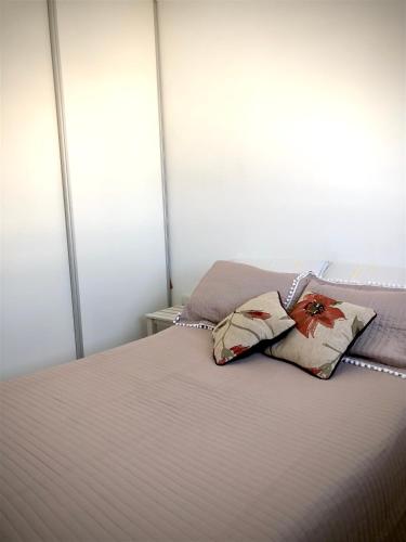 1 dormitorio con 1 cama con 2 almohadas en Apart de la Bahía con cochera en Bahía Blanca