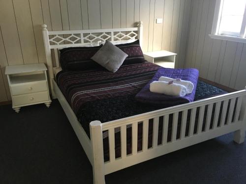 ein Schlafzimmer mit einem weißen Bett mit einem ausgestopften Tier darauf in der Unterkunft Goondihill Hotel in Innisfail