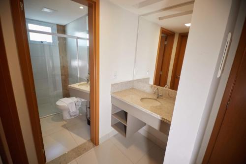 y baño con lavabo, aseo y espejo. en Resort do Lago - Caldas Novas, en Caldas Novas