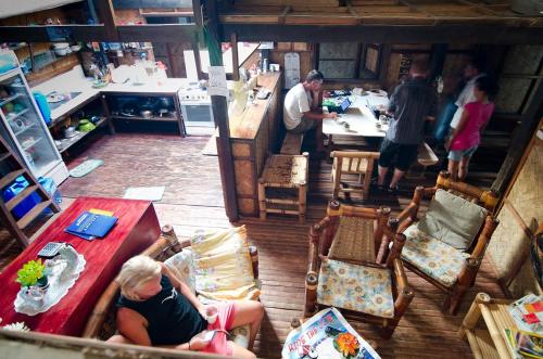 una mujer sentada en una mesa en una sala de estar en Coron Backpacker Guesthouse, en Corón
