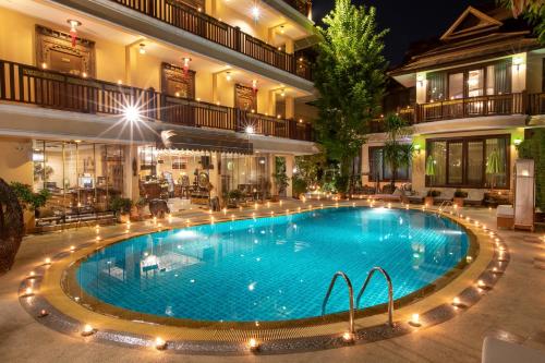 a large swimming pool in a hotel at night at At Chiang Mai Hotel in Chiang Mai