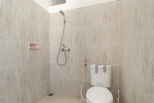 a bathroom with a shower with a toilet in it at KoolKost near T2 Juanda Airport in Sidoarjo