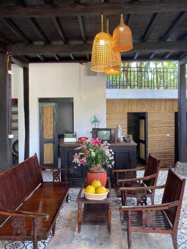 a dining room with chairs and a table with a bowl of fruit at Mai Chau Rustic Home in Mai Chau