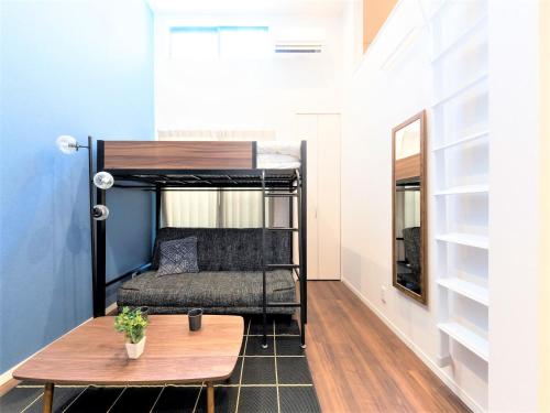een kleine kamer met een stapelbed en een tafel bij TRIP POD SUMIYOSHI A in Fukuoka