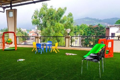 a yard with chairs and a playground on the grass at Dean Villa in Lonavala