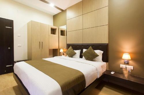 a bedroom with a large bed with two lamps at Dean Villa in Lonavala