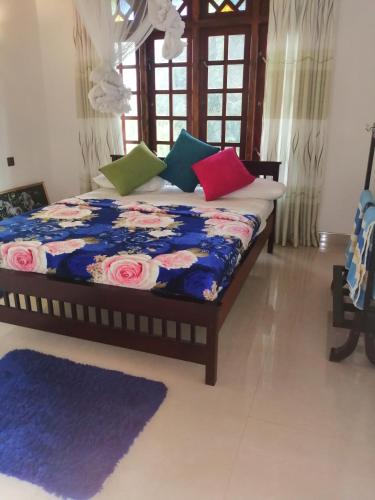 a bed with colorful pillows on it in a room at Sudumal Cottage in Ella