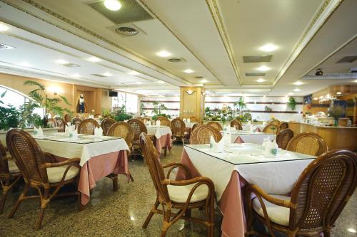 un restaurante con mesas y sillas en una habitación en Kingdom Hotel, en Hsinchu City