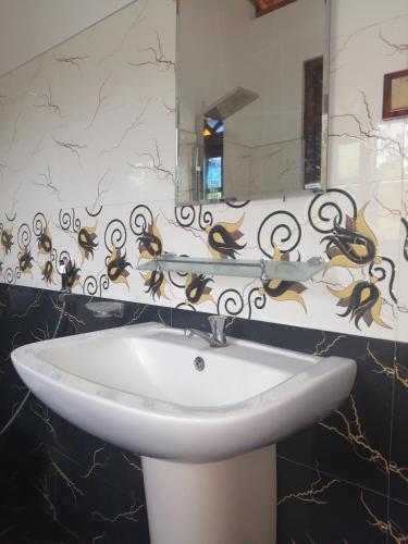 a white sink in a bathroom with a mirror at Sudumal Cottage in Ella