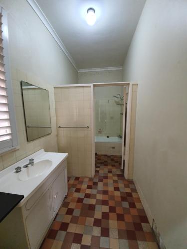 a bathroom with a sink and a shower and a mirror at Grand Hotel in Newcastle