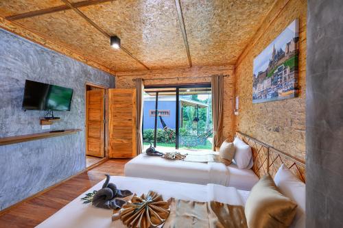 1 dormitorio con 2 camas, TV y ventana en Baan Check In, en Ko Lanta