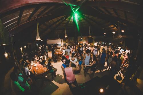 a crowd of people sitting at tables in a room at Mad Monkey Hostel Siargao in General Luna