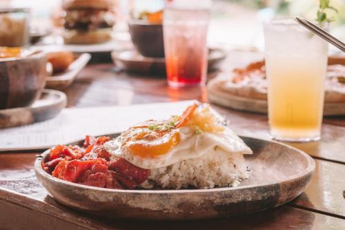 a plate of food with rice and an egg on top at Mad Monkey Hostel Siargao in General Luna