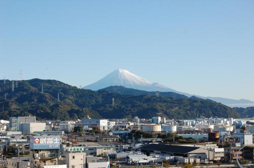 a mountain in the background of a city with buildings at Seagrande Shimizu Station Hotel in Shizuoka