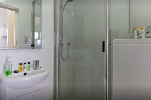 a bathroom with a glass shower and a sink at M102 West Perth Studio Apartment near Kings Park in Perth