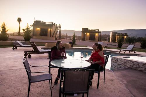 two women sitting at a table with glasses of wine at Cuatro Lunas Hotel Boutique in Valle de Guadalupe