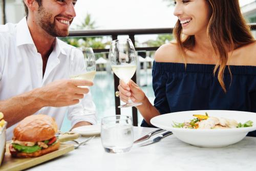 a man and woman sitting at a table with wine glasses at Novotel Chennai Sipcot in Chennai