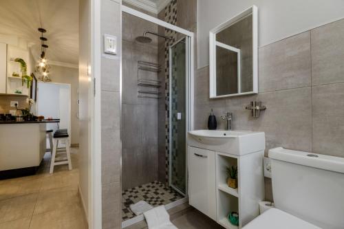a bathroom with a shower and a sink and a toilet at 3-Bedroom Apartment on the Estuary in St Lucia
