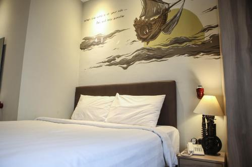 a bedroom with a bed with a painting on the wall at Shine BnB in Tjiandjur