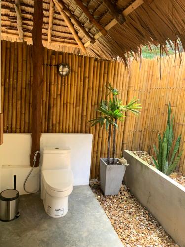 a bathroom with a toilet in a wooden building at Inhale @ Hill in Koh Mook