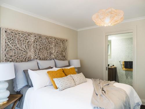 a bedroom with a large white bed with yellow pillows at Chestnut Glade in Narbethong