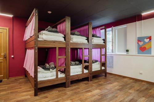 two bunk beds in a room with pink walls at Хостел Sleep&Go Великий Новгород in Velikiy Novgorod